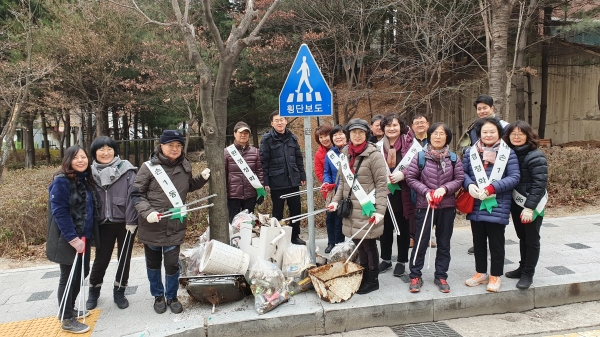 내손1동 사회단체 회원들이 설맞이 대청소 활동에서 수거한 쓰레기 앞에 모여있는 모습
